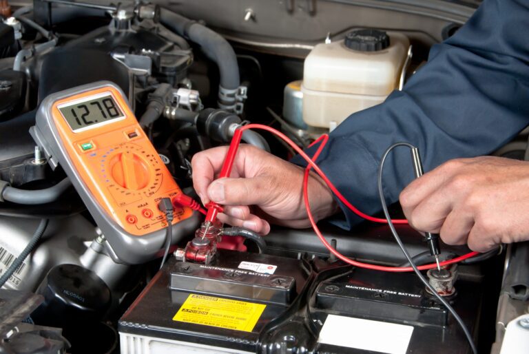 Kisfeszültségű hálózatok típusa Auto mechanic checking car battery voltage