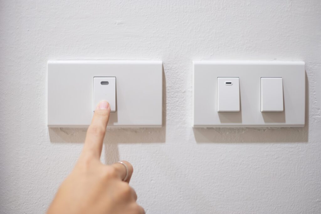 turn on or off on light switch on white wall at home