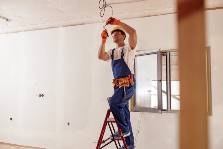 Mi az áramterhelhetőség és miért számít a gyakorlatban? Smiling electrician fixing electric cable on ceiling